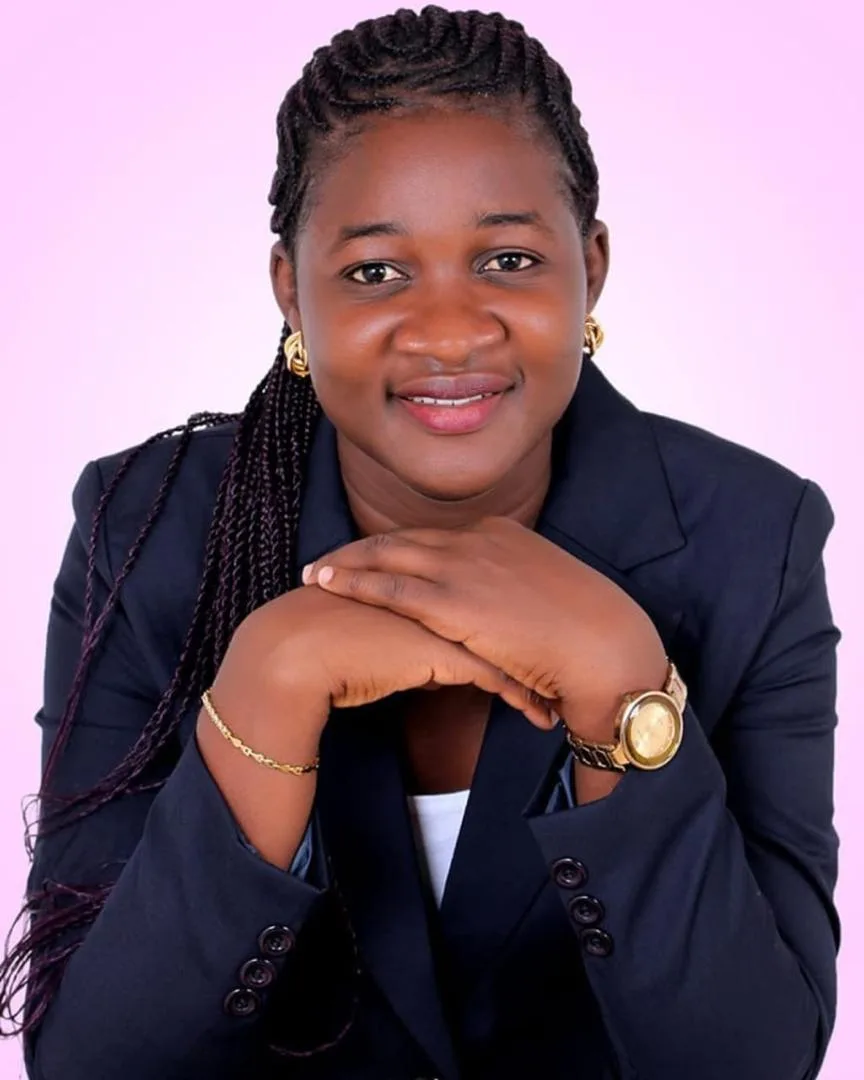 A woman wearing a suit and a gold watch poses for a picture.