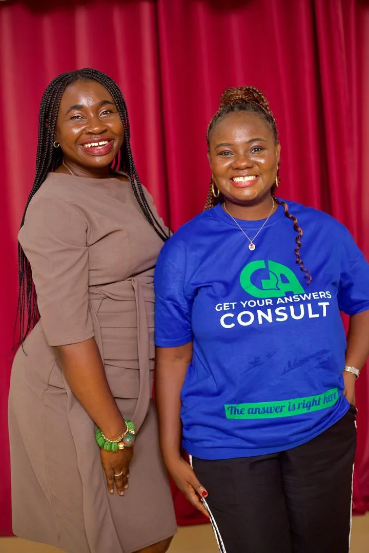 Two women wearing blue shirts with the words "Get Your Answers Consult" on them.